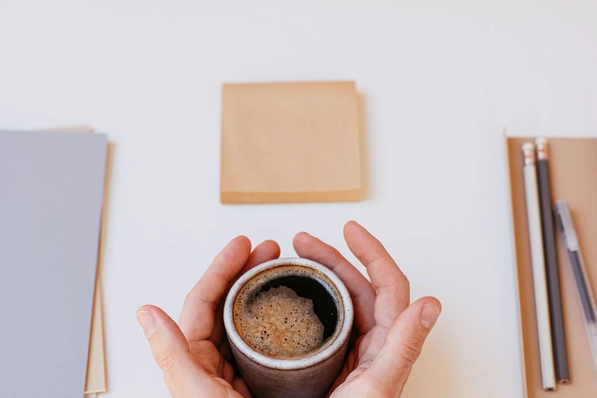 両手でコーヒーカップを包む手元。「まとめ」の話題のイメージ